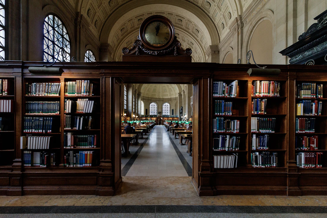 Bookshelves opening into a sunlit university library reading room